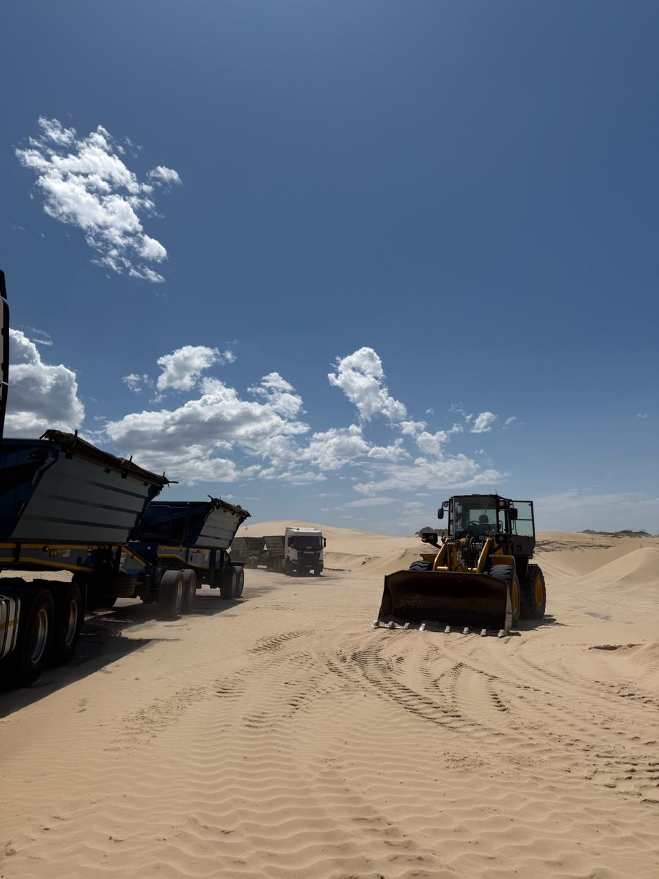 CWG logistics trucks and wheel loader operating on active sand site